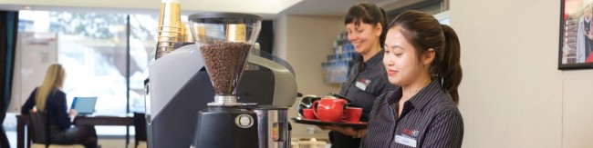 Migrant worker making coffee in a cafe