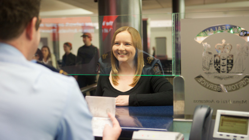 Smiling woman appearing at NZ customs check-in area at airport