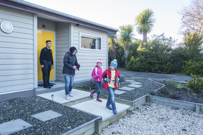 A family in winter clothing leaving their house