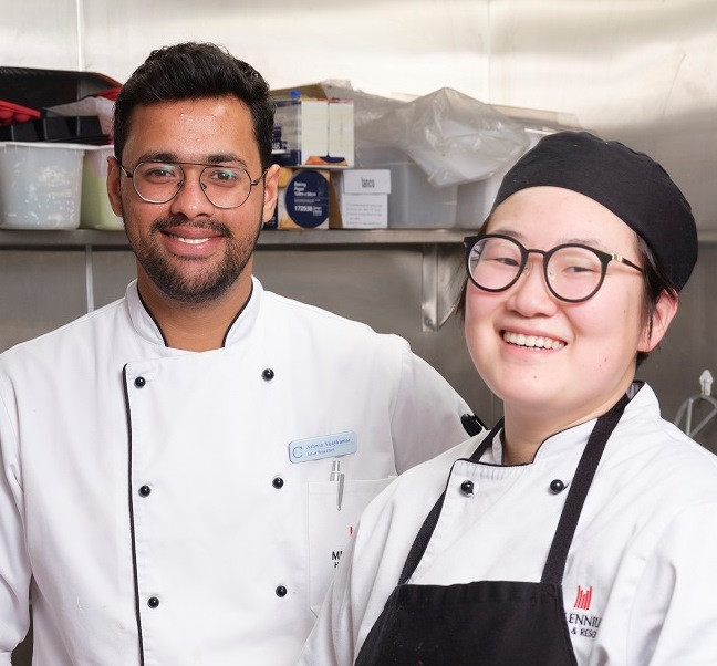 Two migrant hospitality workers smiling