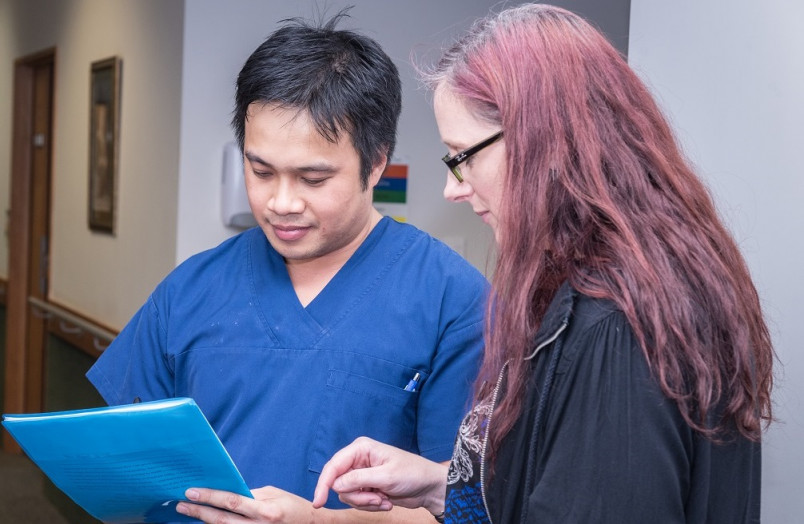 2 workers talking together reviewing notes