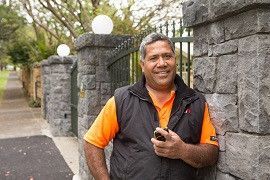 A man leaning against a stone wall