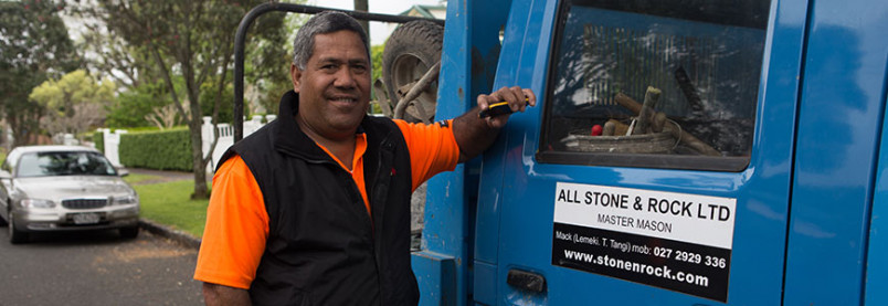 A man standing beside a truck with a sign saying stone mason