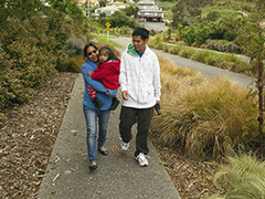 Migrant family walking down path in suburb