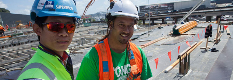 Two men wearing helmets at a construction site