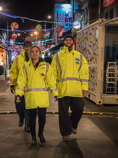 Men and women in yellow uniforms walking down a street