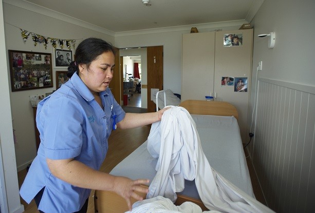 A Pacific worker changes the bedclothes at a retirement village