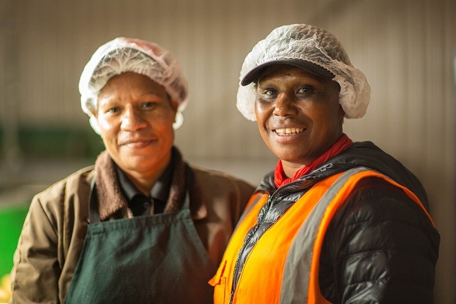 Two PNG workers smile for the camera