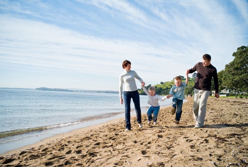 Family walking on Cheltenham Beach, Auckland