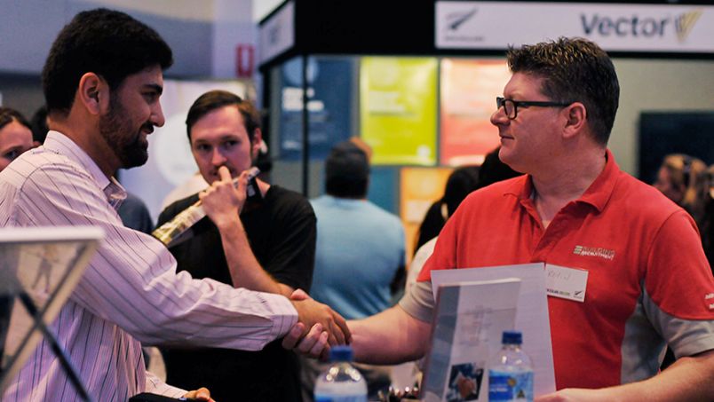 Visitor shaking hands with another person at an expo